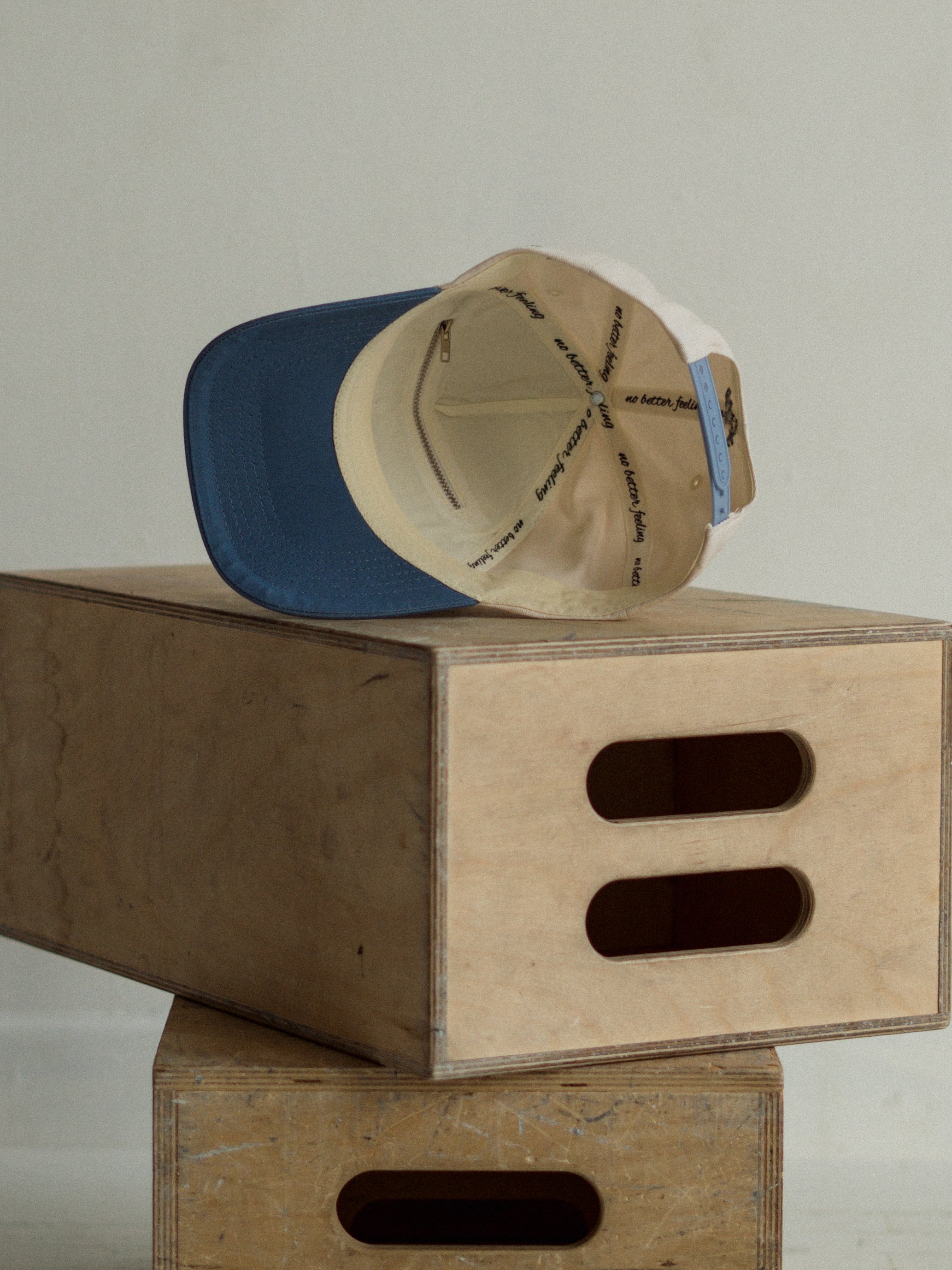 A baseball cap on top of a wooden box with a plain background
