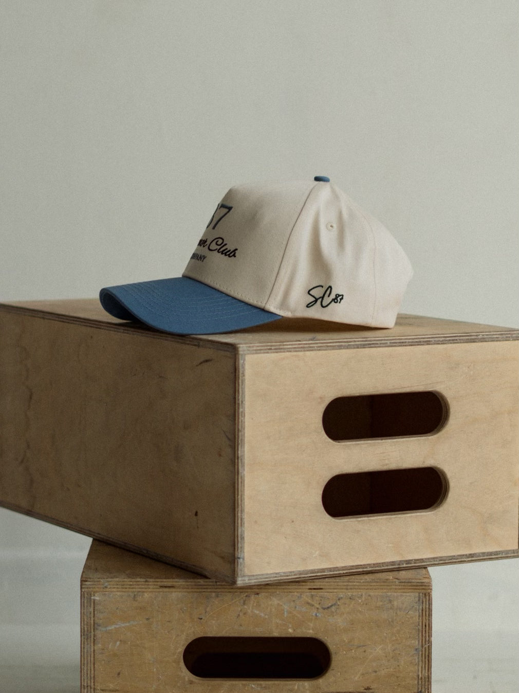 A cap on top of wooden crates with a plain background